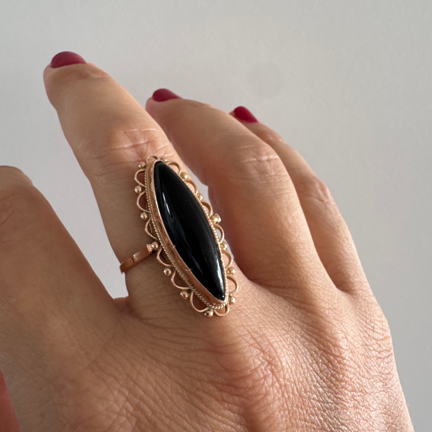 טבעת זהב אדום 14 קראט משובצת אבן אוניקס שחורה בחיתוך מרקיזה עם מבנה מאורך