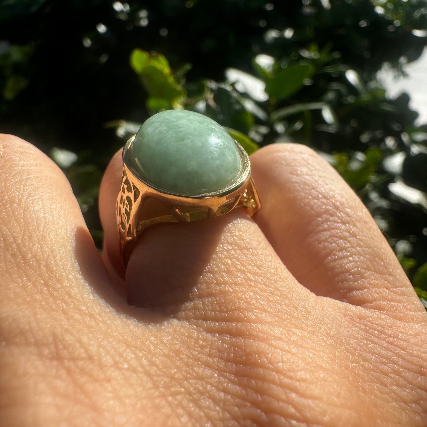 14K gold ring featuring a large oval light green Jade with a smooth polished finish, set in a classic bezel setting.