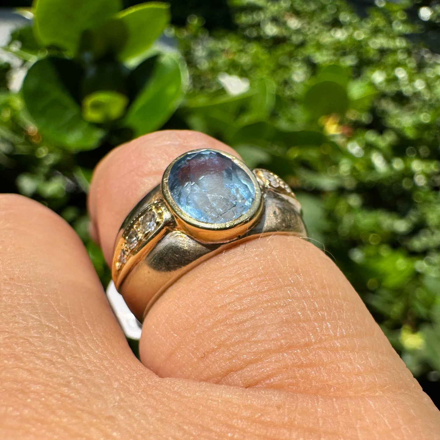 14K gold ring set with a luminous Blue Topaz at its center, accented by delicate side Diamonds