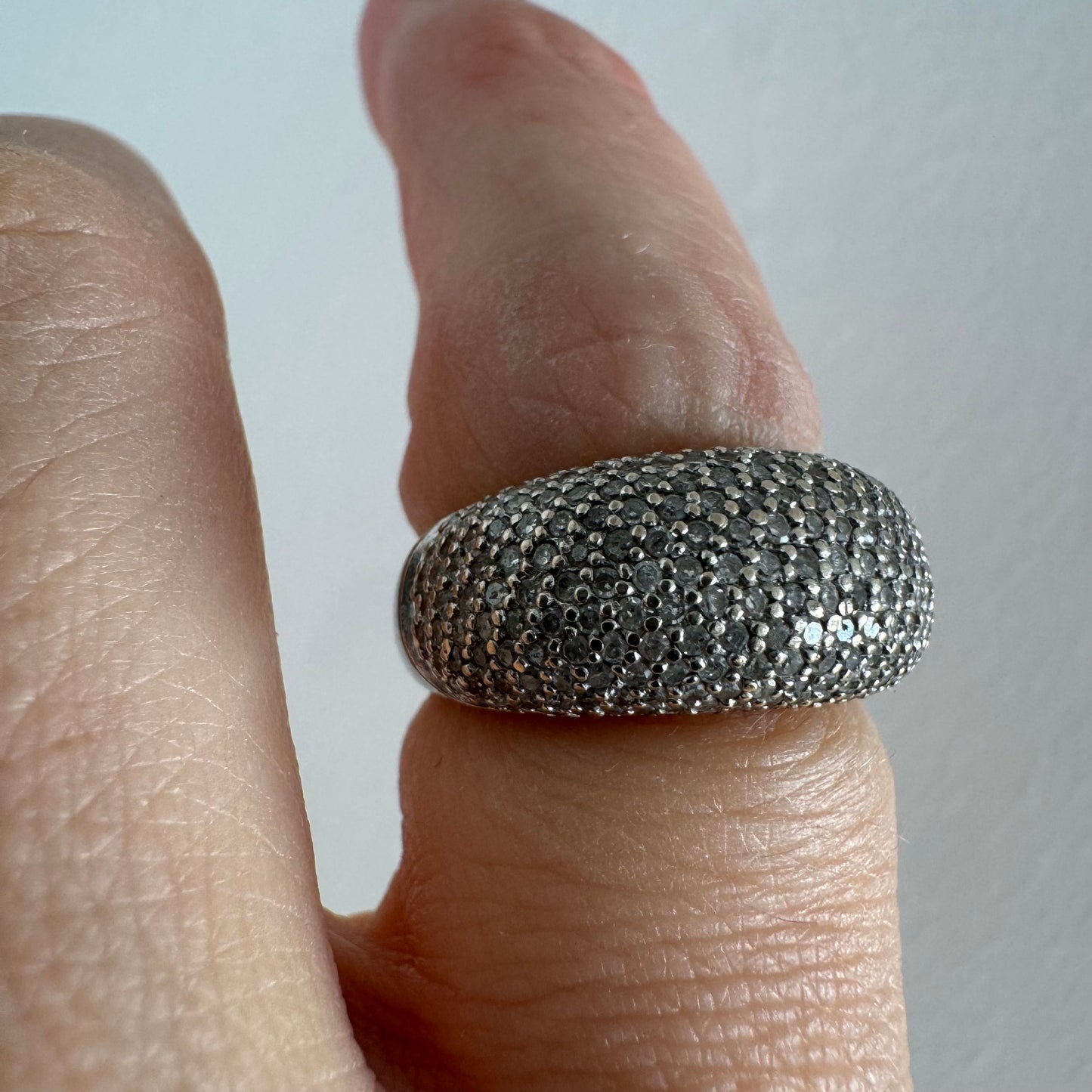 טבעת זהב לבן 14 קראט בעיצוב כיפה רחבה, משובצת יהלומים זעירים בשיבוץ פאבה צפוף.