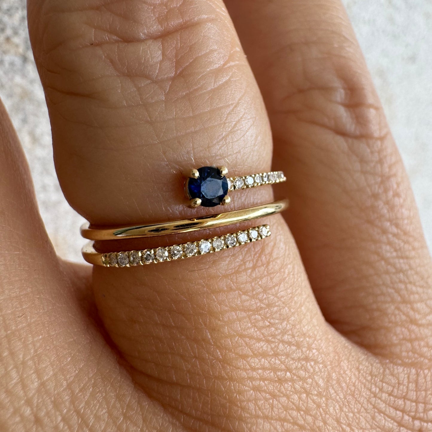 טבעת זהב צהוב 14 קראט משובצת אבן ספיר כחולה ויהלומים נוצצים בשורות עדינות.