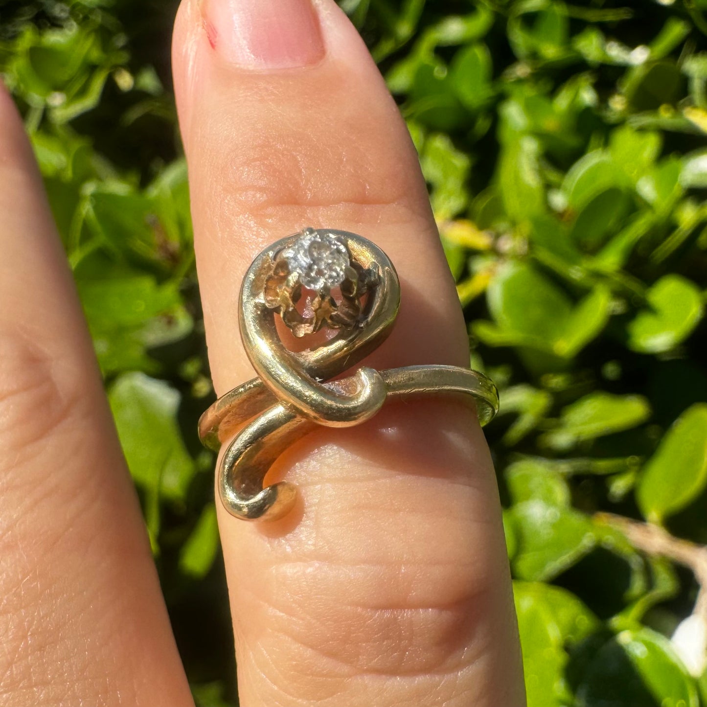 14K gold ring set with a brilliant-cut Diamond, embraced by a flowing, sculptural gold design