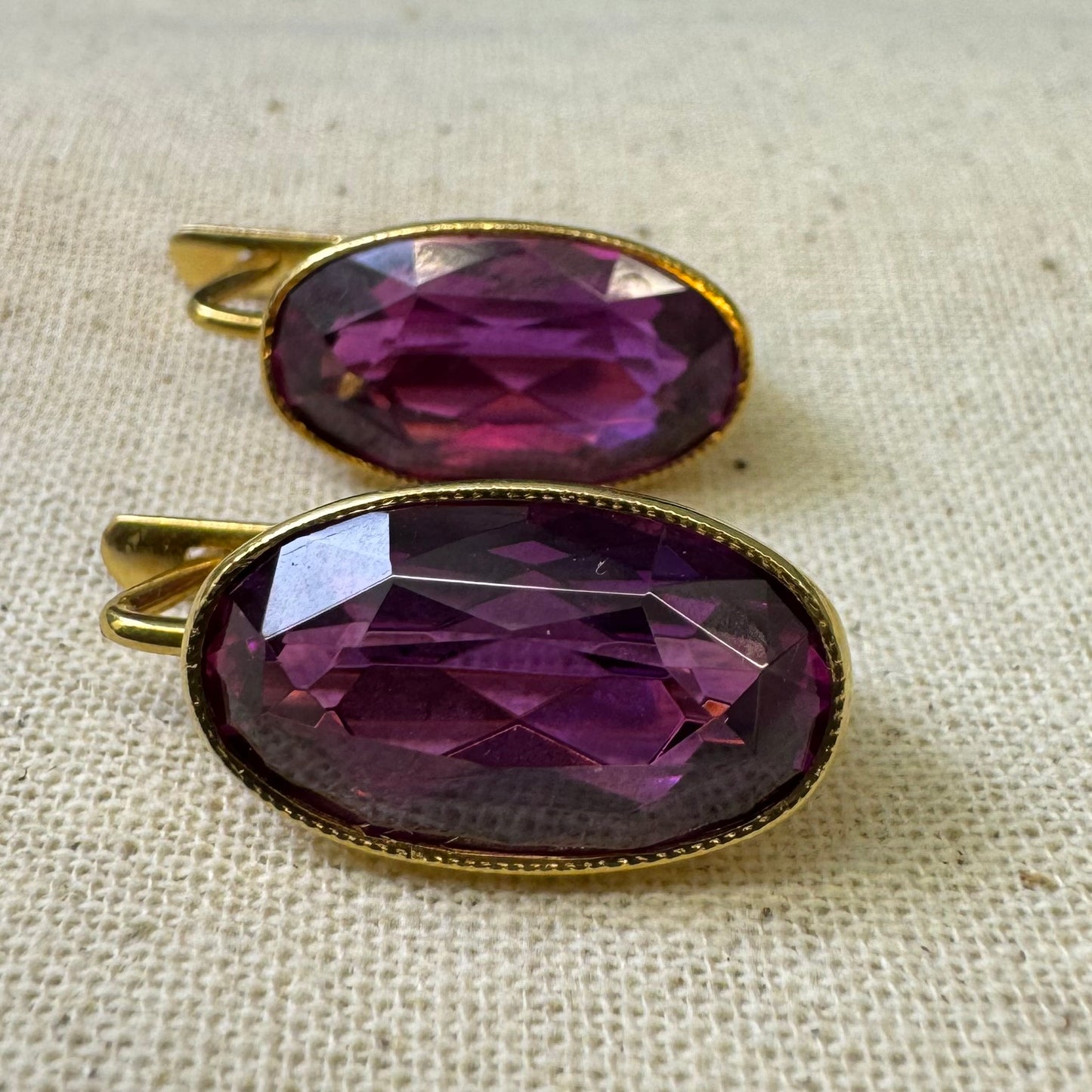 עגילי זהב צהוב 18 קראט, תלויים קצרים, משובצים באבני אמטיסט סגולות בחיתוך אובלי עמוק.