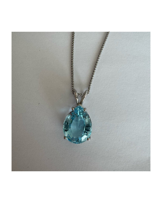 תליון זהב לבן 14 קראט המשובץ אבן טופז כחולה בחיתוך טיפה.