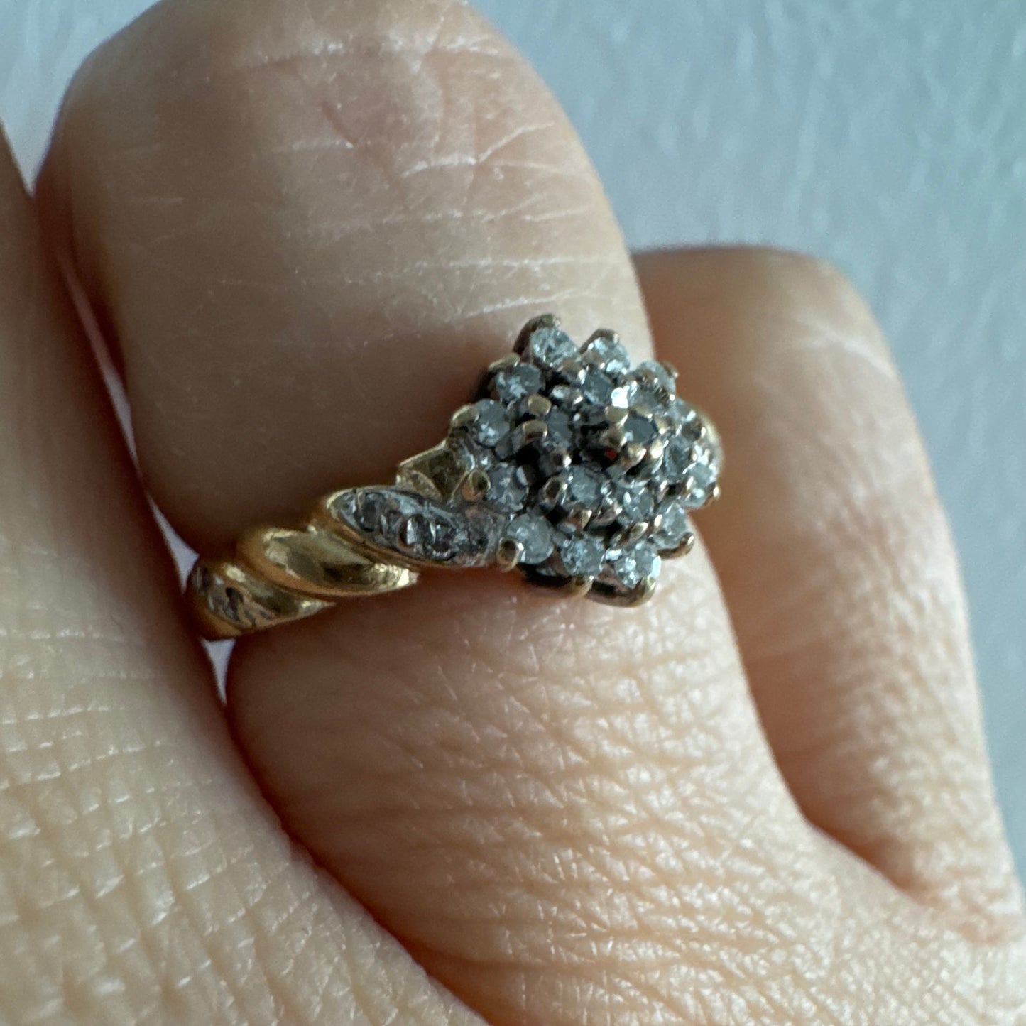 טבעת זהב צהוב 9 קראט משובצת יהלומים בעיצוב פרח עדין.