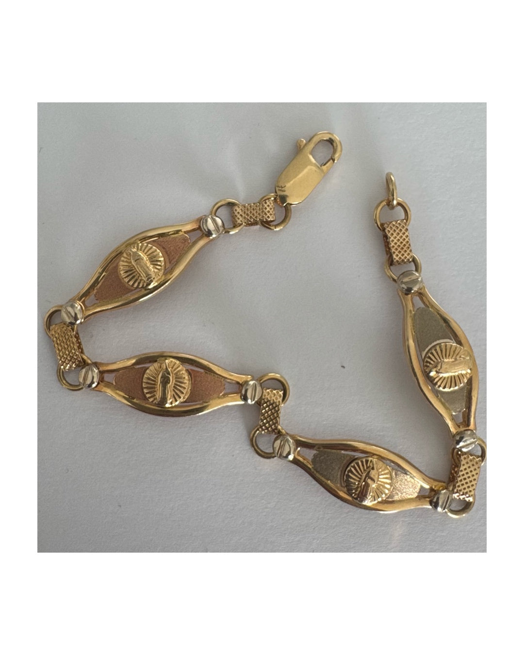 צמיד זהב צהוב 14 קראט עם אלמנט מרכזי בדמות מריה הקדושה, מוקפת קרני אור.