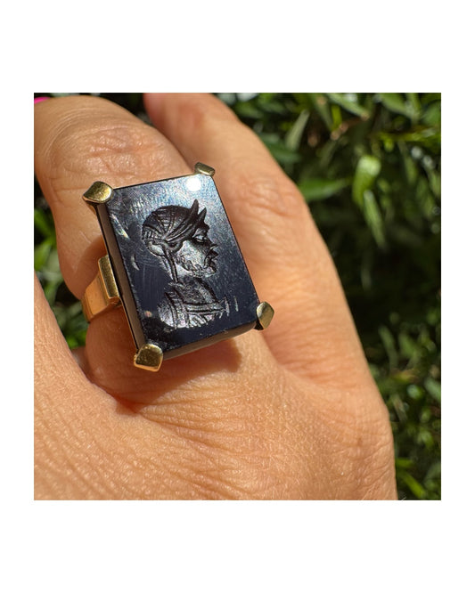 טבעת זהב צהוב 18 קראט משובצת אבן כהה עליה חרוט דיוקן של לוחם קלאסי