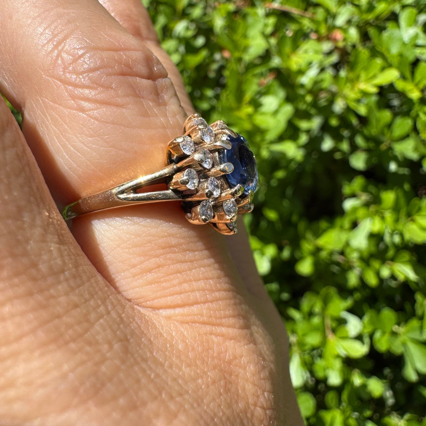 14K gold ring set with a vivid blue Sapphire surrounded by a sparkling halo of brilliant-cut Diamonds