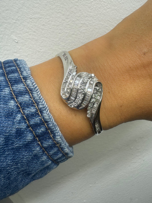 צמיד מרהיב מזהב לבן 14 קראט, בעיצוב גלים דינמי המשובץ בשיבוץ מרוכב של יהלומים עגולים ובחיתוך באגט.