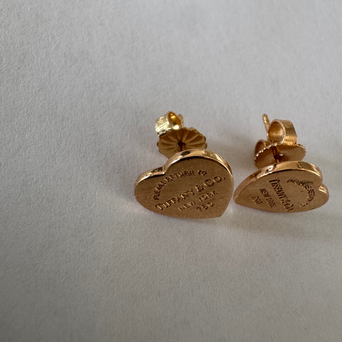 עגילים צמודים של Tiffany &amp; Co. עשויים זהב 18 קראט (750), בעיצוב לב אייקוני עם חריטת “Please Return to Tiffany & Co. New York”. 