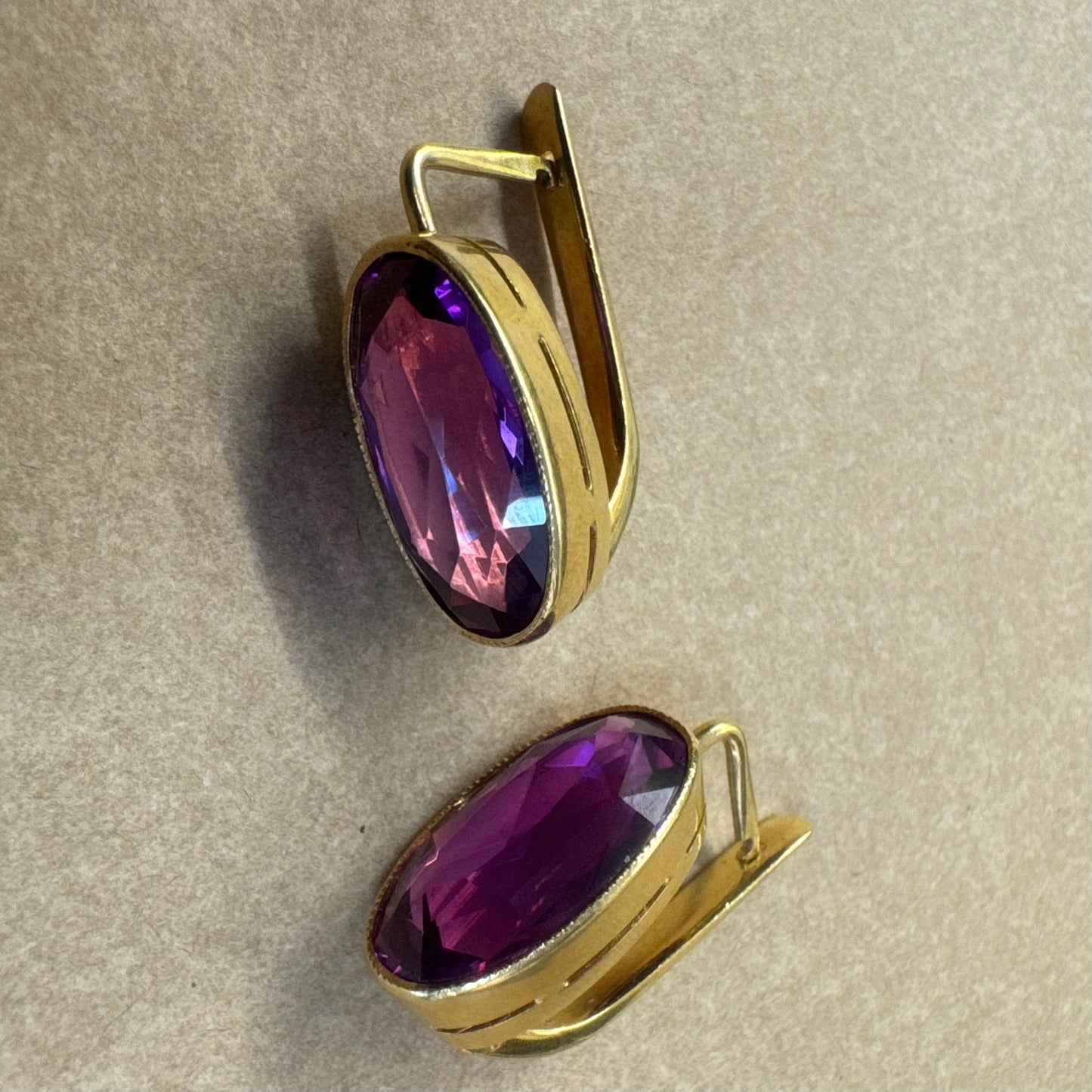 עגילי זהב צהוב 18 קראט, תלויים קצרים, משובצים באבני אמטיסט סגולות בחיתוך אובלי עמוק.