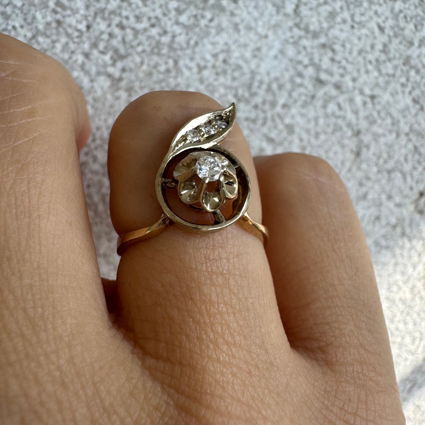 טבעת זהב צהוב 14 קראט בעיצוב פרח עדין המשובצת יהלומים נוצצים .