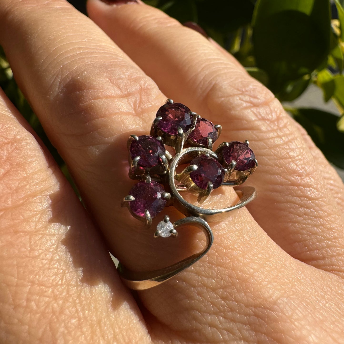 14K gold ring with an open, flowing design, set with multiple pink Tourmaline stones and accented by a Diamond
