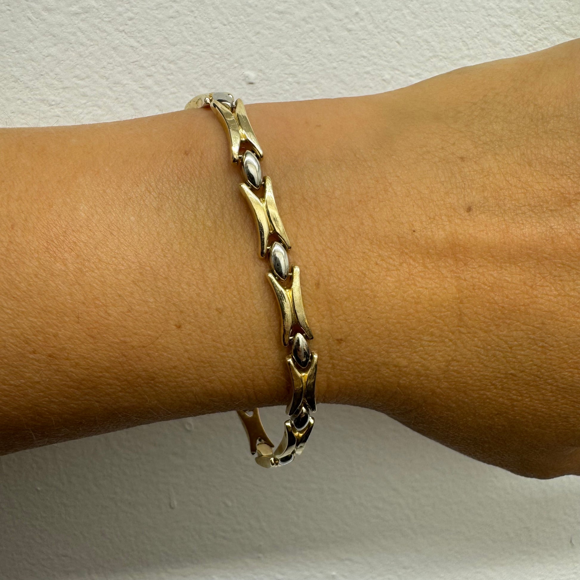 צמיד זהב צהוב וזהב לבן 14 קראט בעיצוב גאומטרי מיוחד, עם חיבורים בצורת X מזהב צהוב ושיבוצים מבריקים בזהב לבן