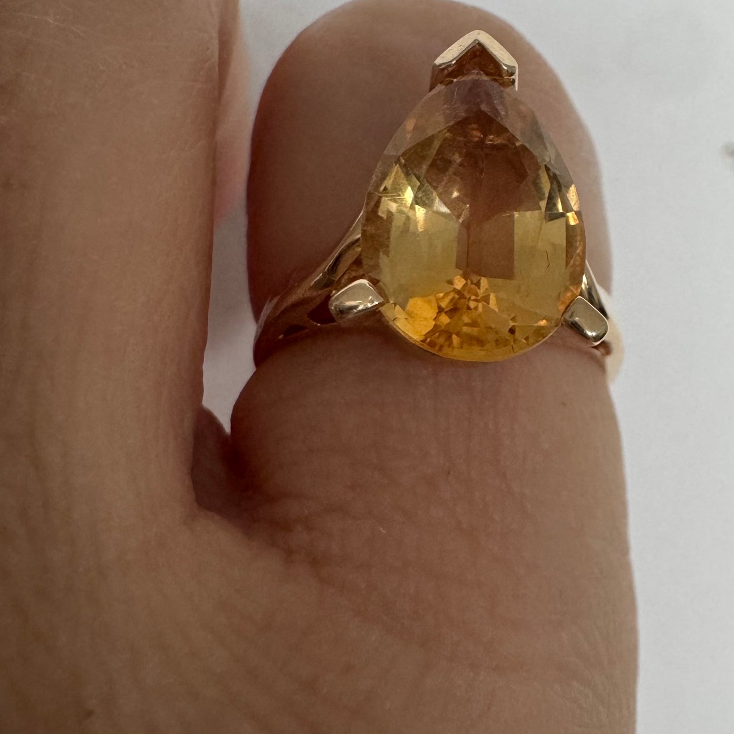 טבעת זהב צהוב 14 קראט משובצת באבן סיטרין גדולה בחיתוך טיפה, עם זהב שמחבק אותה בצורה פתוחה ומודרנית.