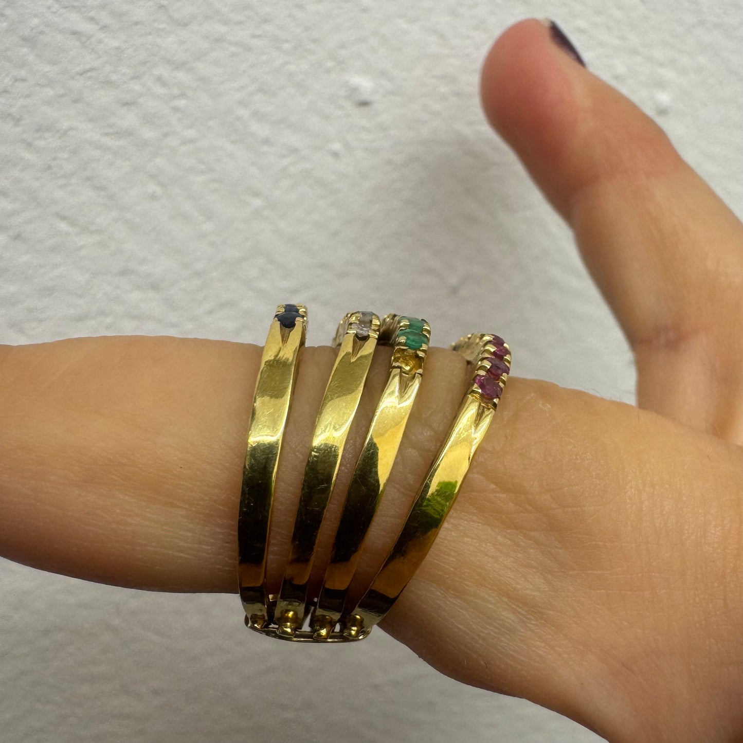 18K yellow gold ring set with vibrant rows of Sapphires, Emeralds, Rubies, and Diamonds