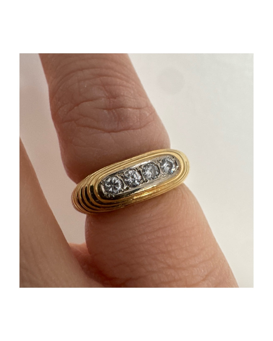 טבעת זהב צהוב 14 קראט בעיצוב אליפטי מוארך, משובצת חמישה יהלומים עגולים בשיבוץ תעלה.