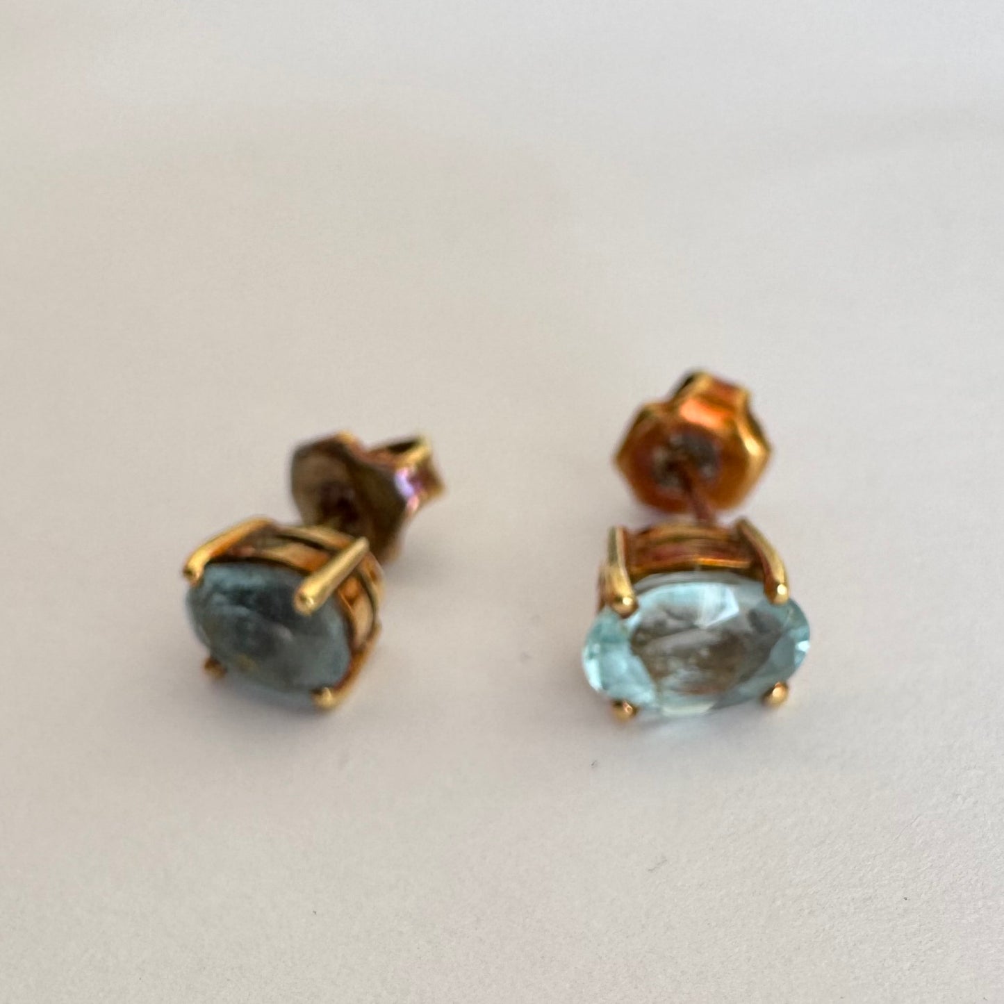 18K gold stud earrings set with oval-cut Aquamarines.