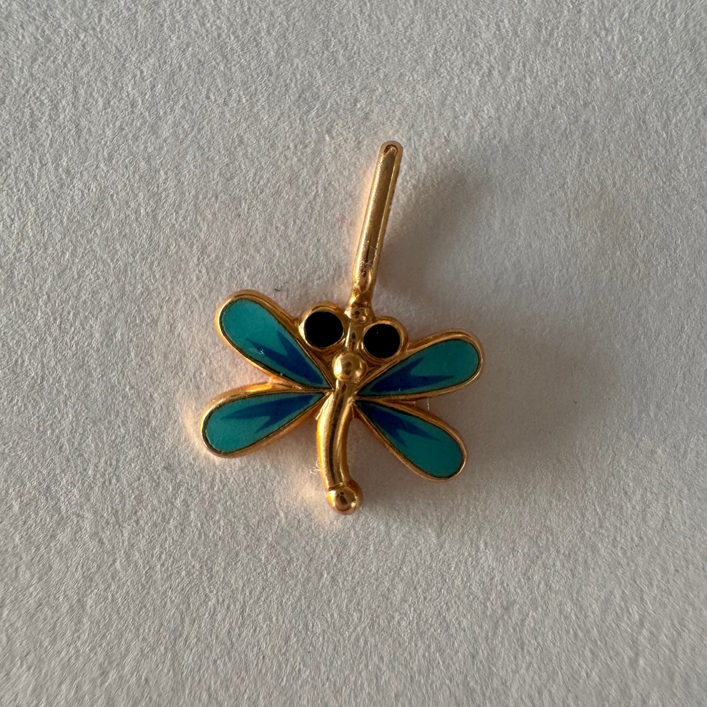 תליון זהב 14 קראט בעיצוב שפירית, עם עבודת אמייל כחולה ופרטים עדינים שמעניקים לו מראה צבעוני ואלגנטי.