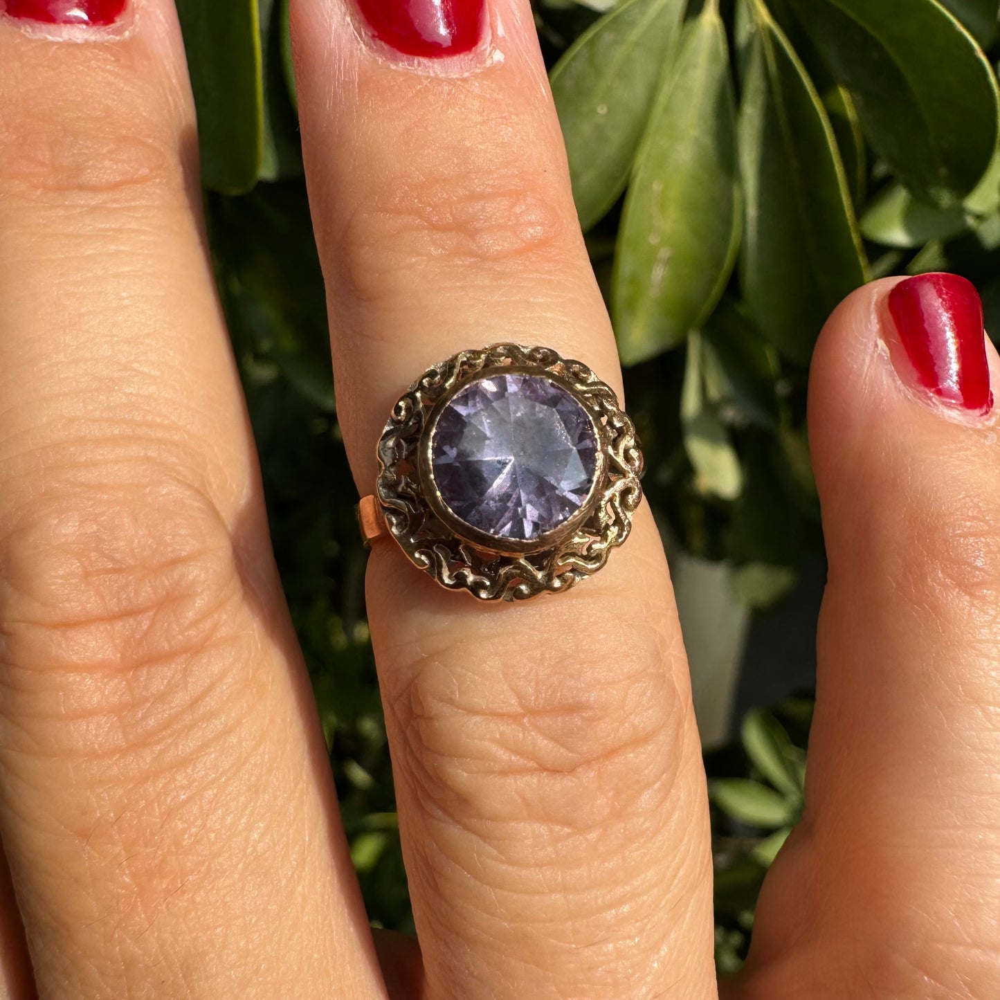 14K gold ring set with a large round-cut Tanzanite framed by an ornate filigree bezel