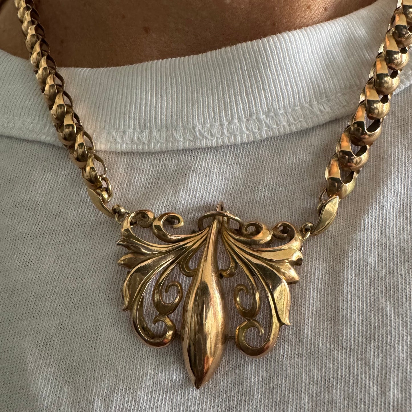 שרשרת זהב 14 קראט בעלת עיטור פלר דה ליס (Fleur-de-lis) אמנותי, המעוצב בקווים מעוגלים של עלי שושן בסגנון אר נובו.