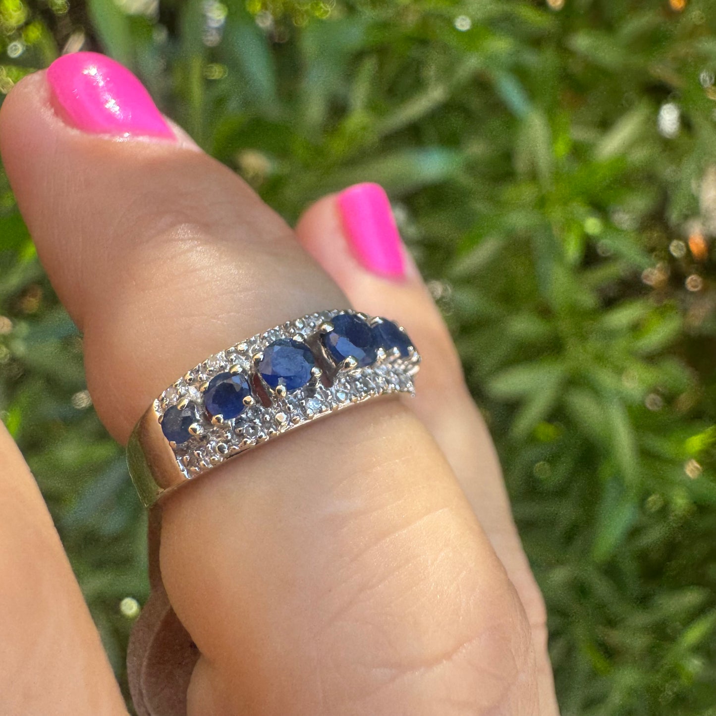 18K gold ring set with deep blue sapphires in a classic round cut, framed by two shimmering rows of brilliant Diamonds.