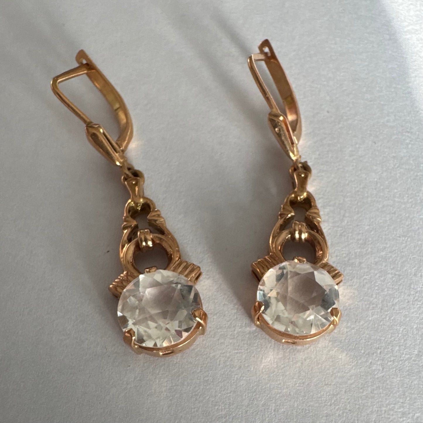 עגילי זהב 14 קראט, תלויים, בעיצוב עדין ונוסטלגי, משובצים באבני חן חתוכות שקופות בסגנון עתיק.