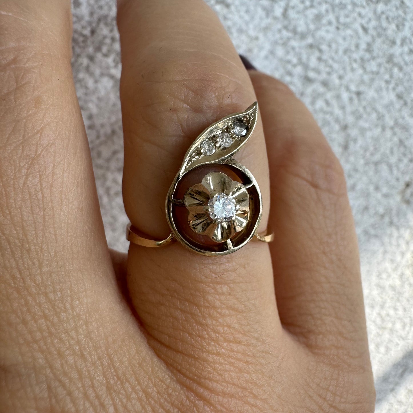 טבעת זהב צהוב 14 קראט בעיצוב פרח עדין המשובצת יהלומים נוצצים .