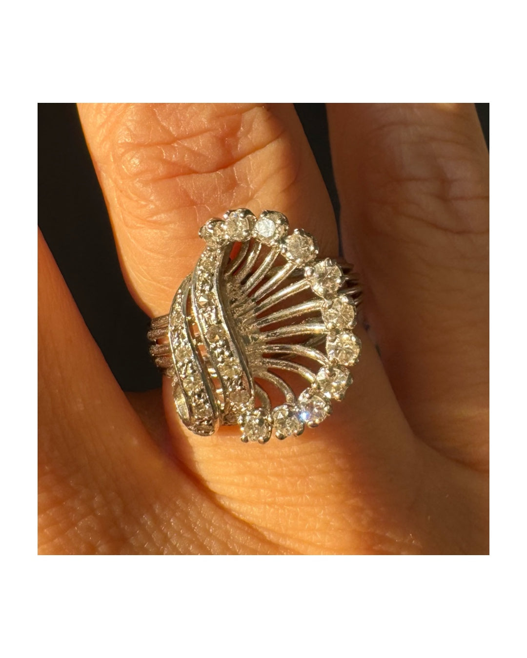 טבעת זהב 18 קראט משובצת יהלומים בעיצוב ייחודי ודינמי, עם קווים פתוחים ומניפת יהלומים היקפית היוצרת מראה עשיר ומלא ברק