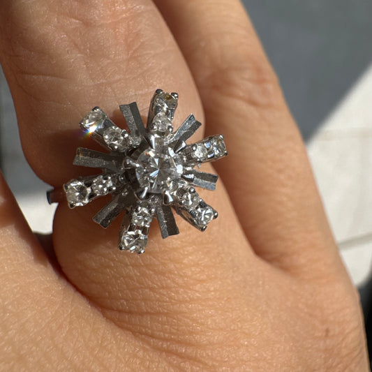 טבעת זהב לבן 18 קראט בעיצוב קרני שמש מרהיב, משובצת יהלומים הלוכדים את האור מכל כיוון. 