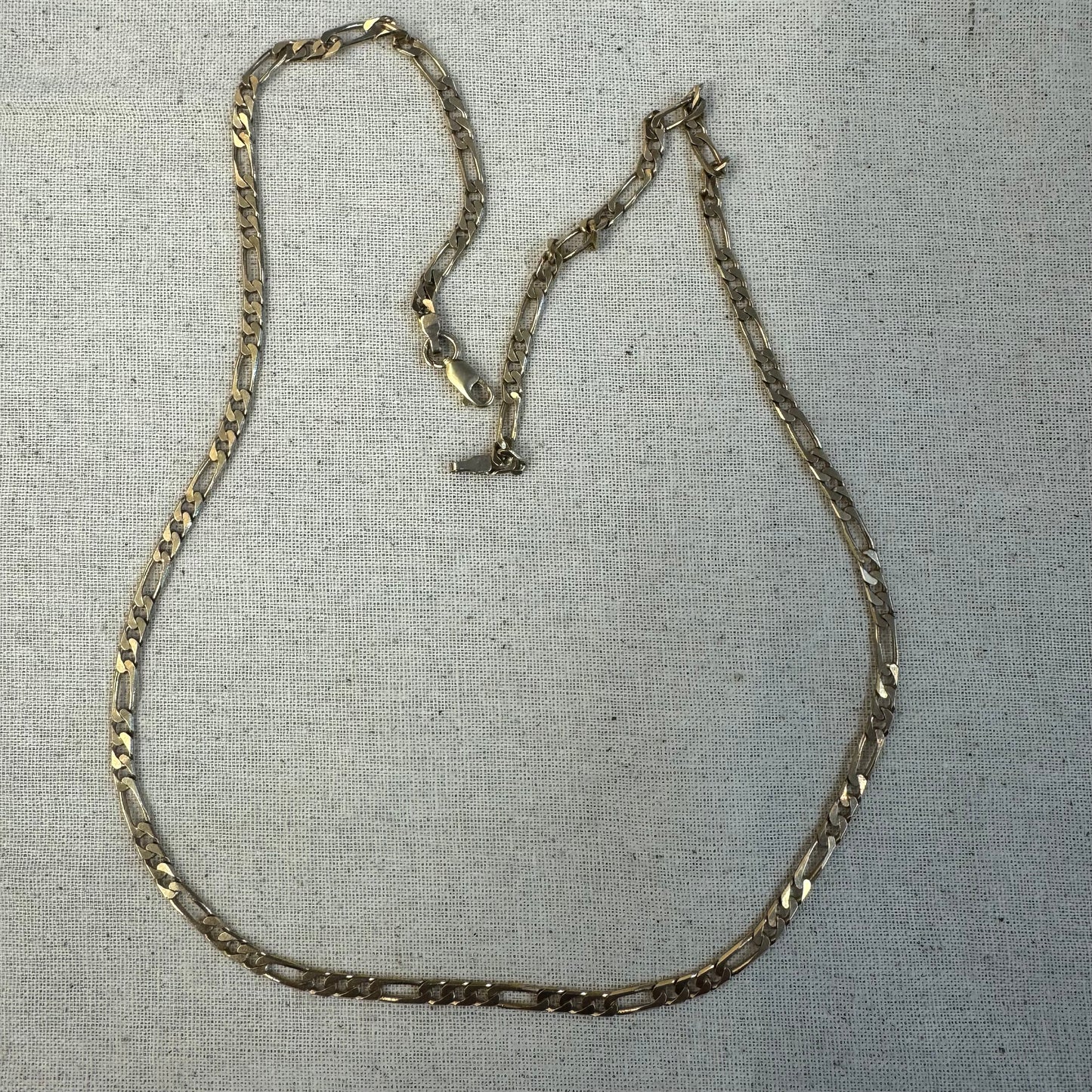 שרשרת זהב 14 קראט בסגנון Figaro chain – עיצוב קלאסי שבו חוליות קצרות מתחלפות עם חוליה אחת ארוכה.