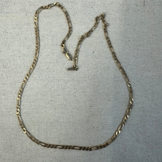 שרשרת זהב 14 קראט בסגנון Figaro chain – עיצוב קלאסי שבו חוליות קצרות מתחלפות עם חוליה אחת ארוכה.