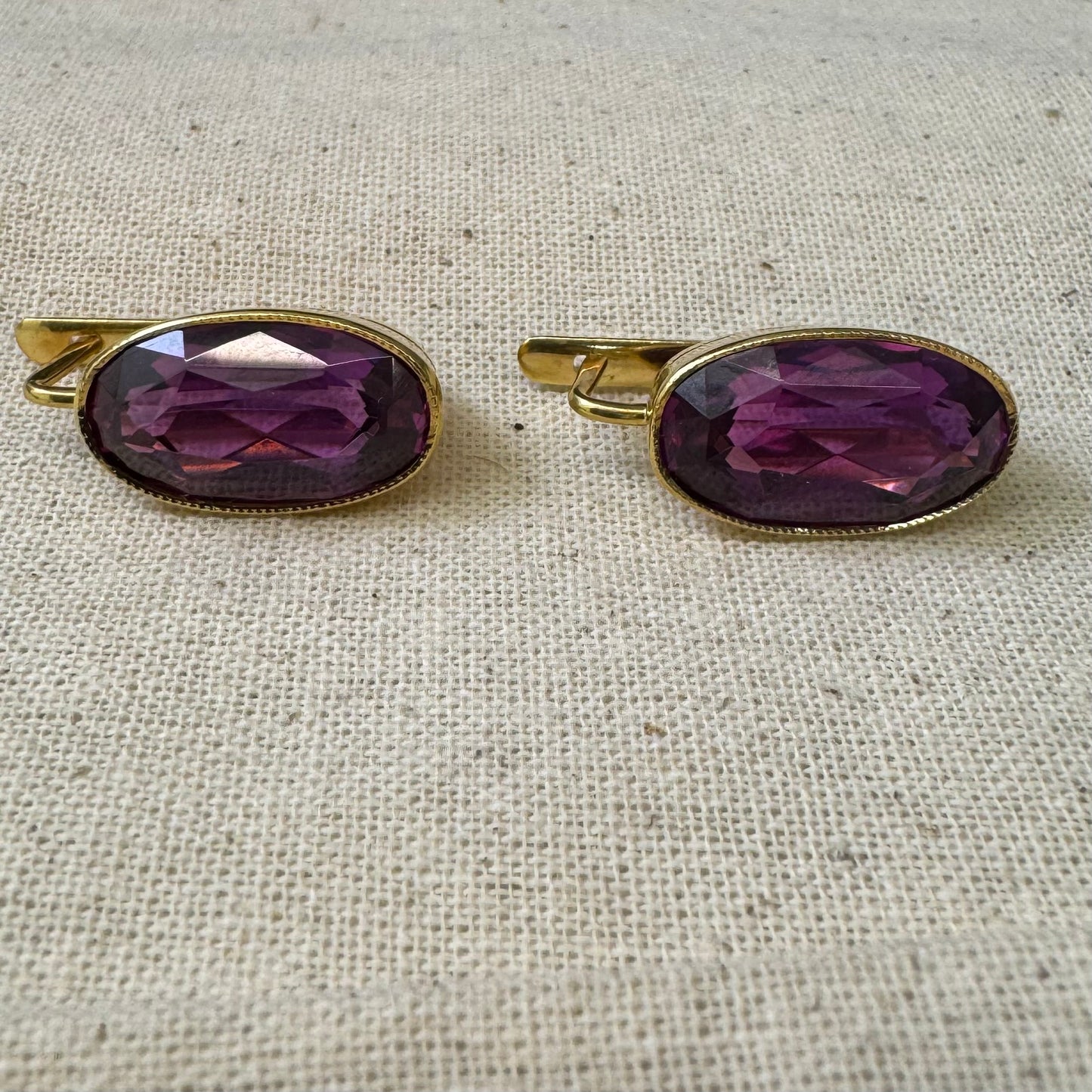 עגילי זהב צהוב 18 קראט, תלויים קצרים, משובצים באבני אמטיסט סגולות בחיתוך אובלי עמוק.