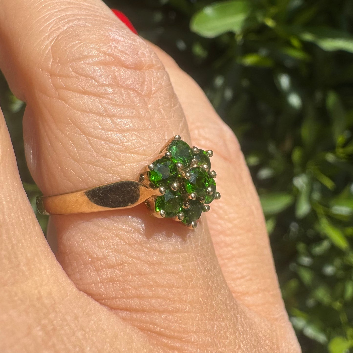 10K gold ring set with vivid green gemstones in a delicate floral cluster
