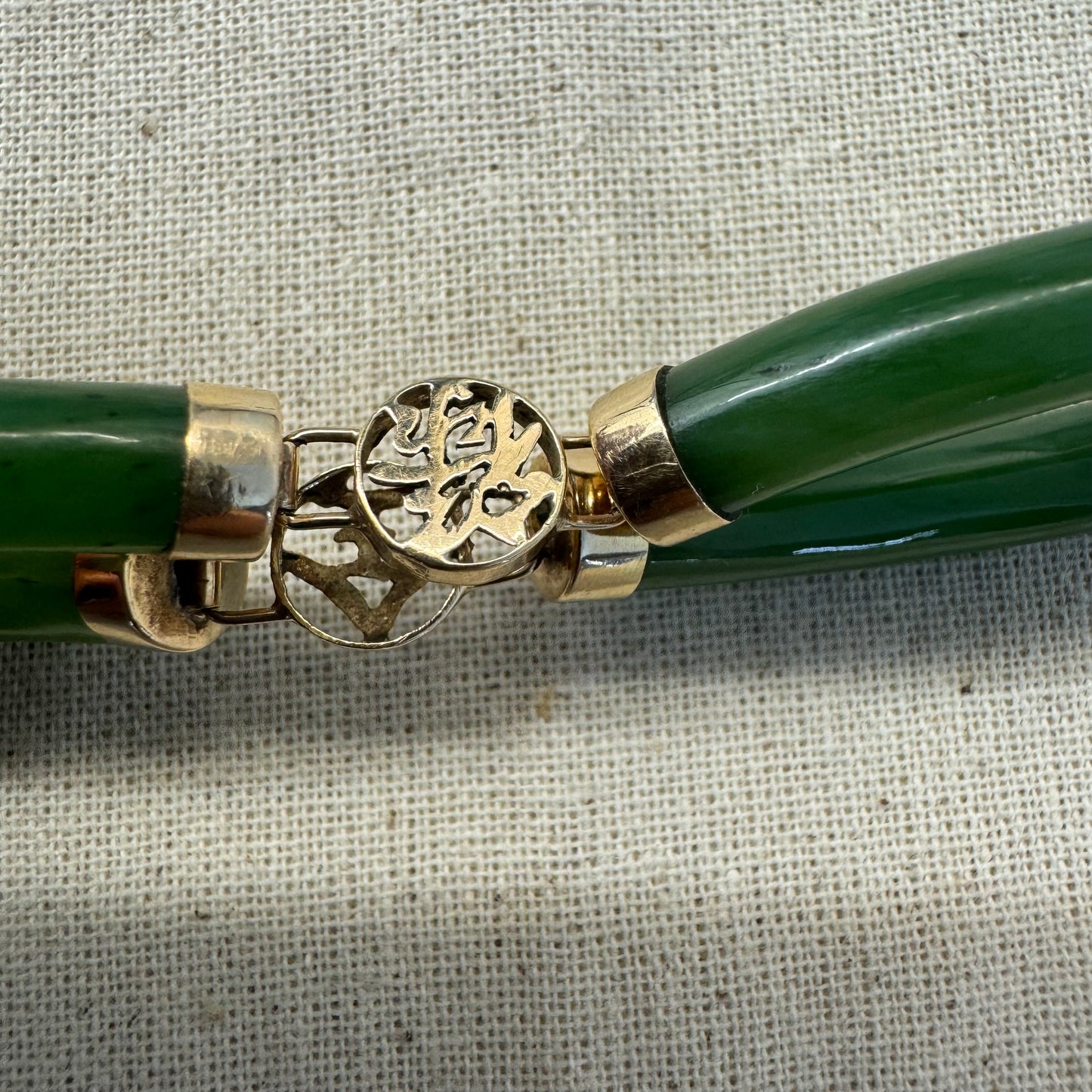 צמיד זהב צהוב 18 קראט משובץ אבני ג’ייד ירוקות עם עיטורי זהב בעיצוב אסייתי מסורתי – שילוב הרמוני של אלגנטיות, משמעות רוחנית וסטייל ייחודי