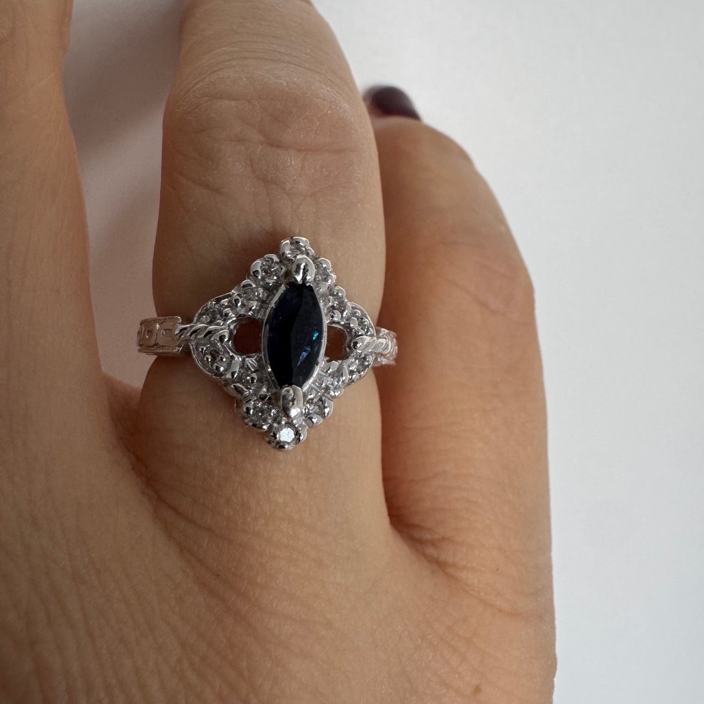 טבעת זהב לבן 14 קראט משובצת אבן ספיר בצבע כחול כהה בחיתוך מרקיזה ומסביב משובצים יהלומים