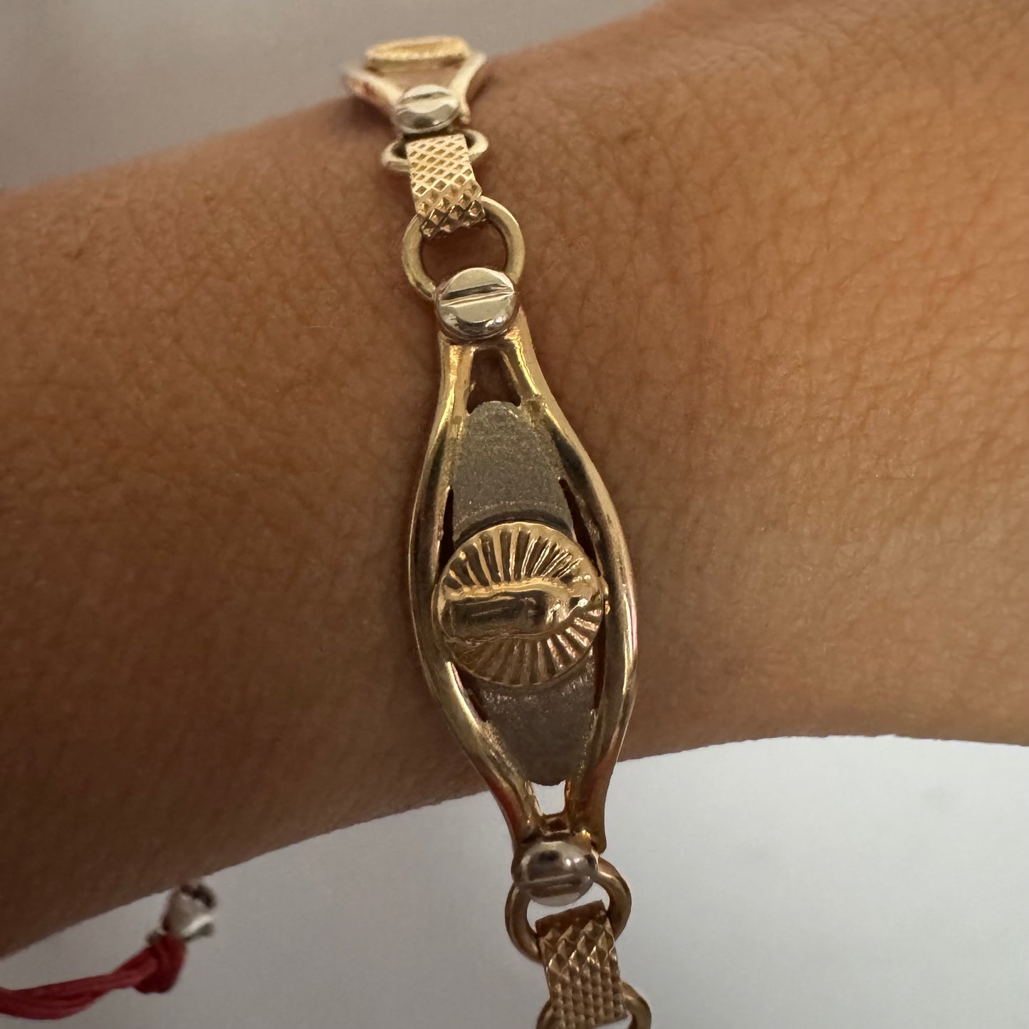 צמיד זהב צהוב 14 קראט עם אלמנט מרכזי בדמות מריה הקדושה, מוקפת קרני אור.