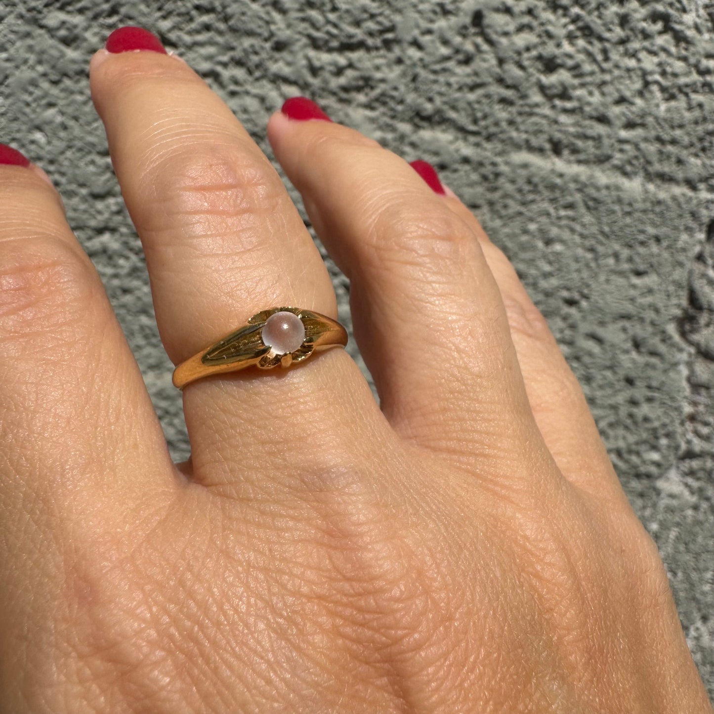 18K yellow gold ring featuring a smooth round Moonstone set in a delicate floral-inspired design.