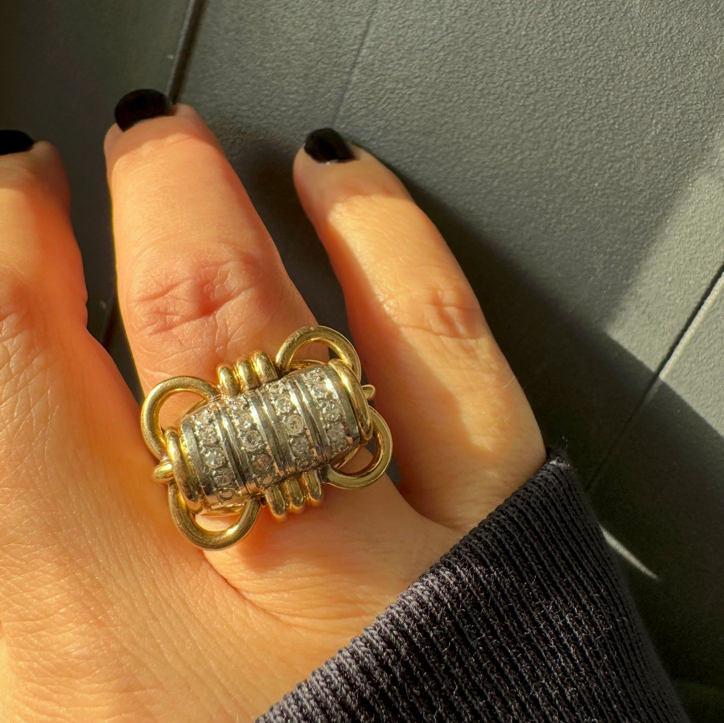 טבעת זהב צהוב ולבן 18 קראט עם מרכז בצורת חבית, משובצת יהלומים נוצצים.