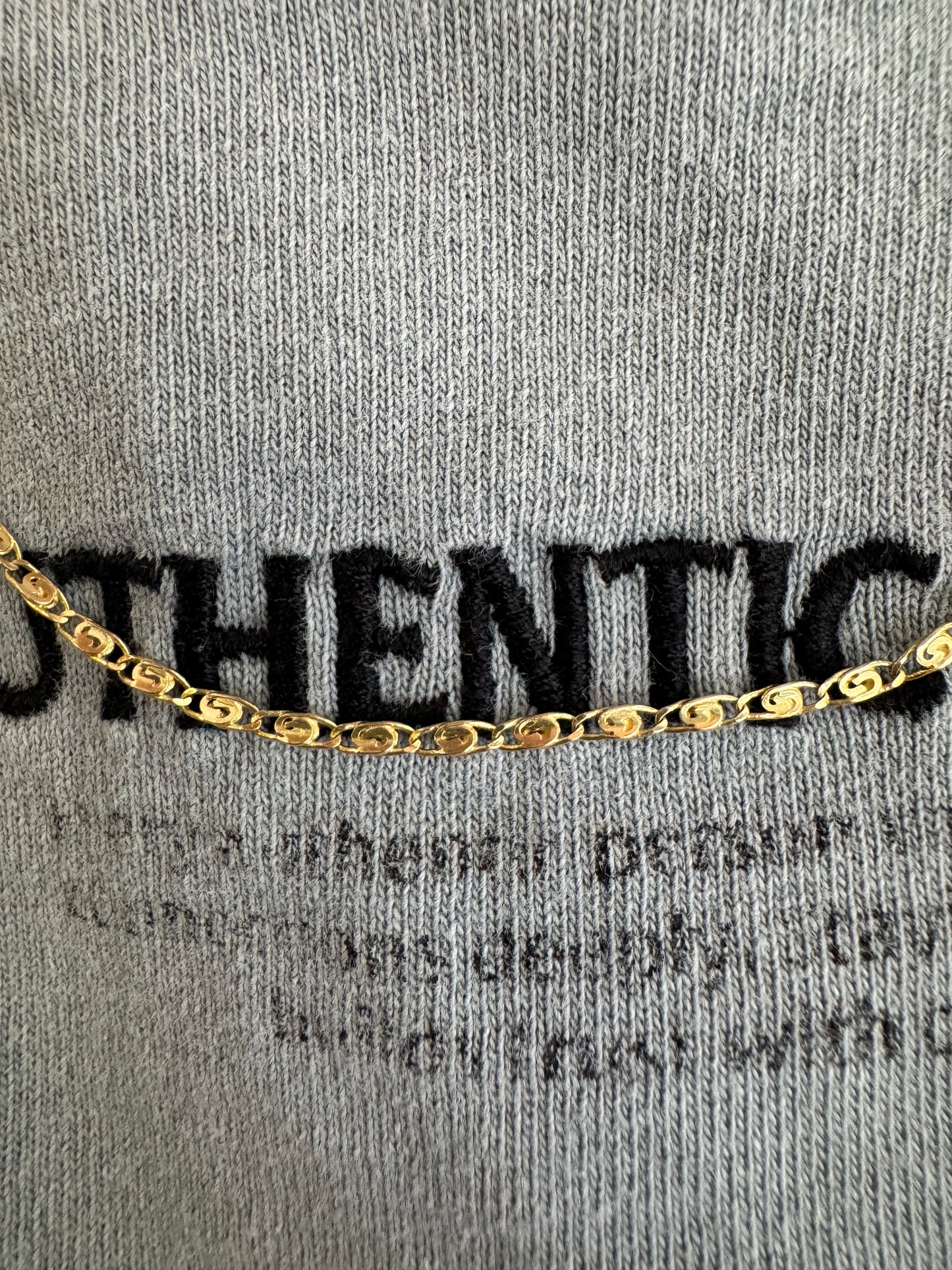 14K gold necklace featuring oval-shaped links with a subtle decorative pattern.