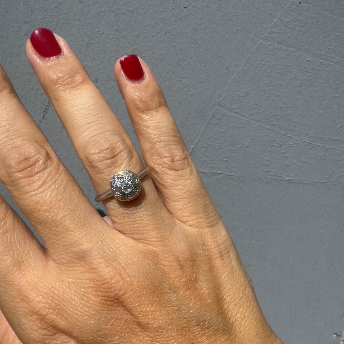 A platinum ring featuring a round cluster of sparkling Diamonds set at the center, creating a bold and elegant look.