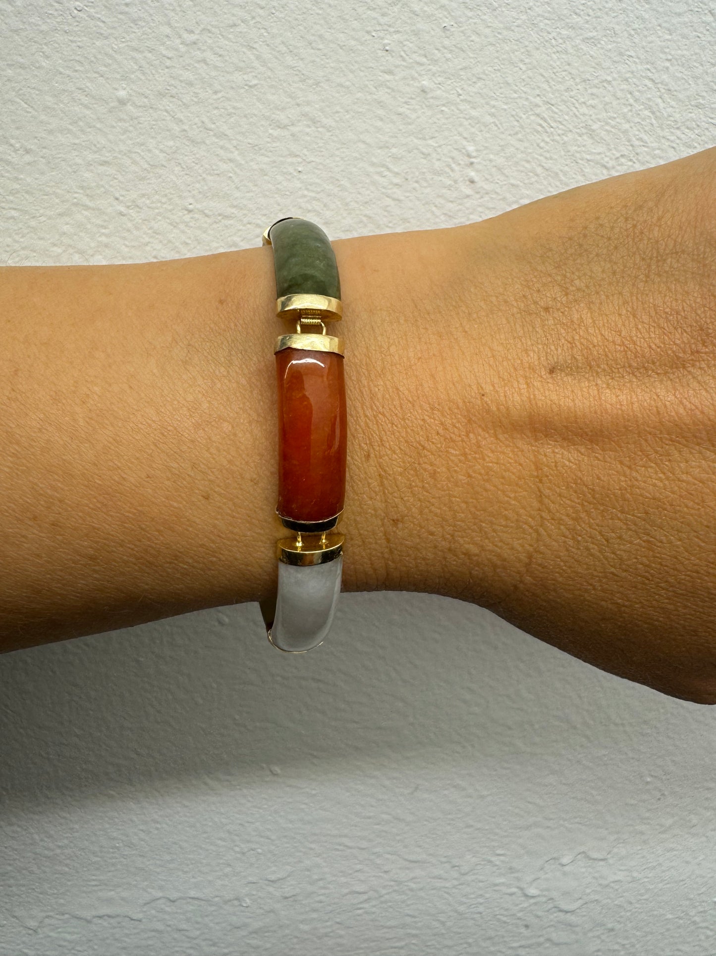 צמיד זהב צהוב 14 קראט עשוי מקטעי ג’ייד (jade) בשלושה גוונים – ירקרק, לבן ואדום – בשיבוץ זהב.