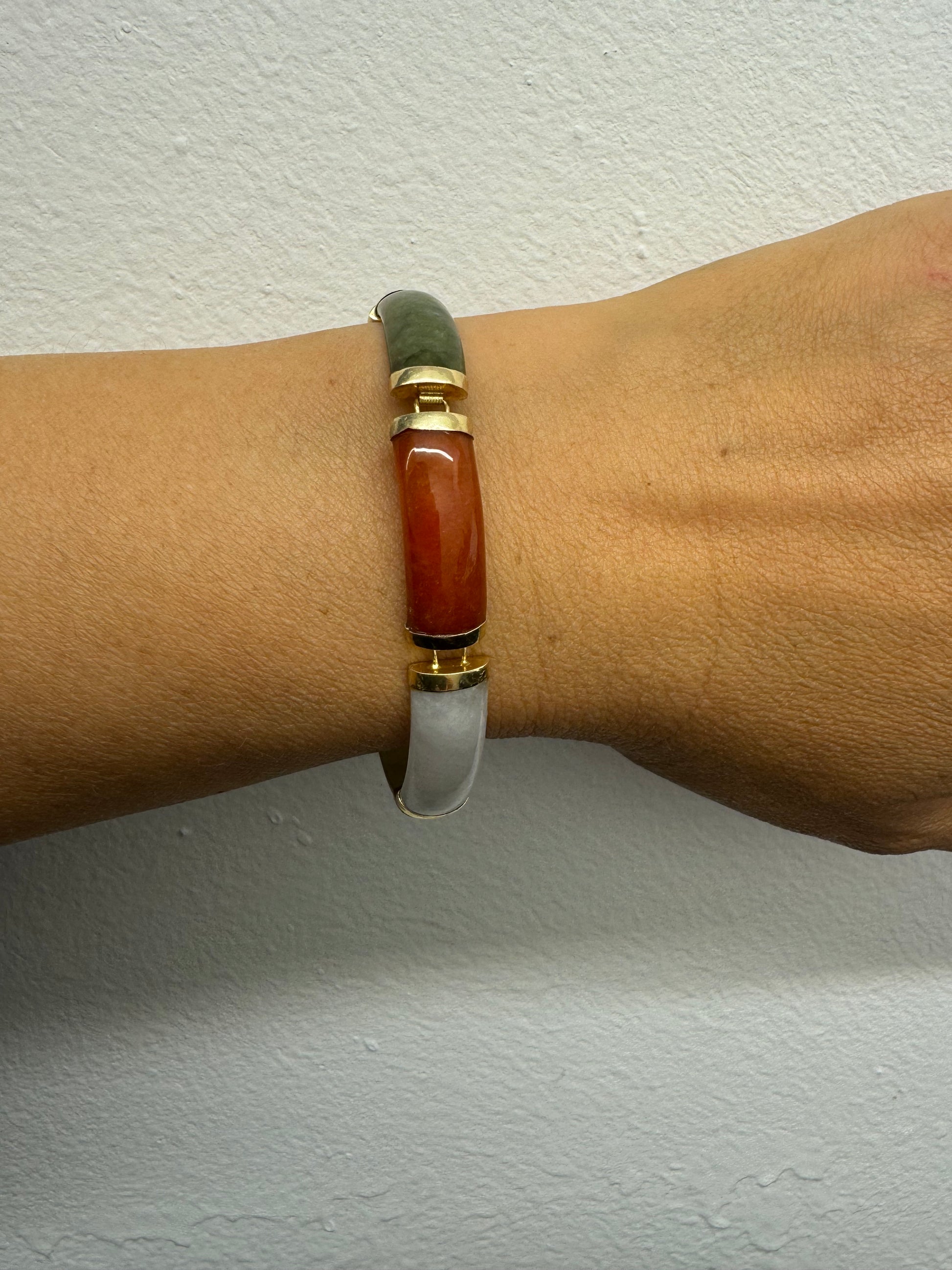 צמיד זהב צהוב 14 קראט עשוי מקטעי ג’ייד (jade) בשלושה גוונים – ירקרק, לבן ואדום – בשיבוץ זהב.