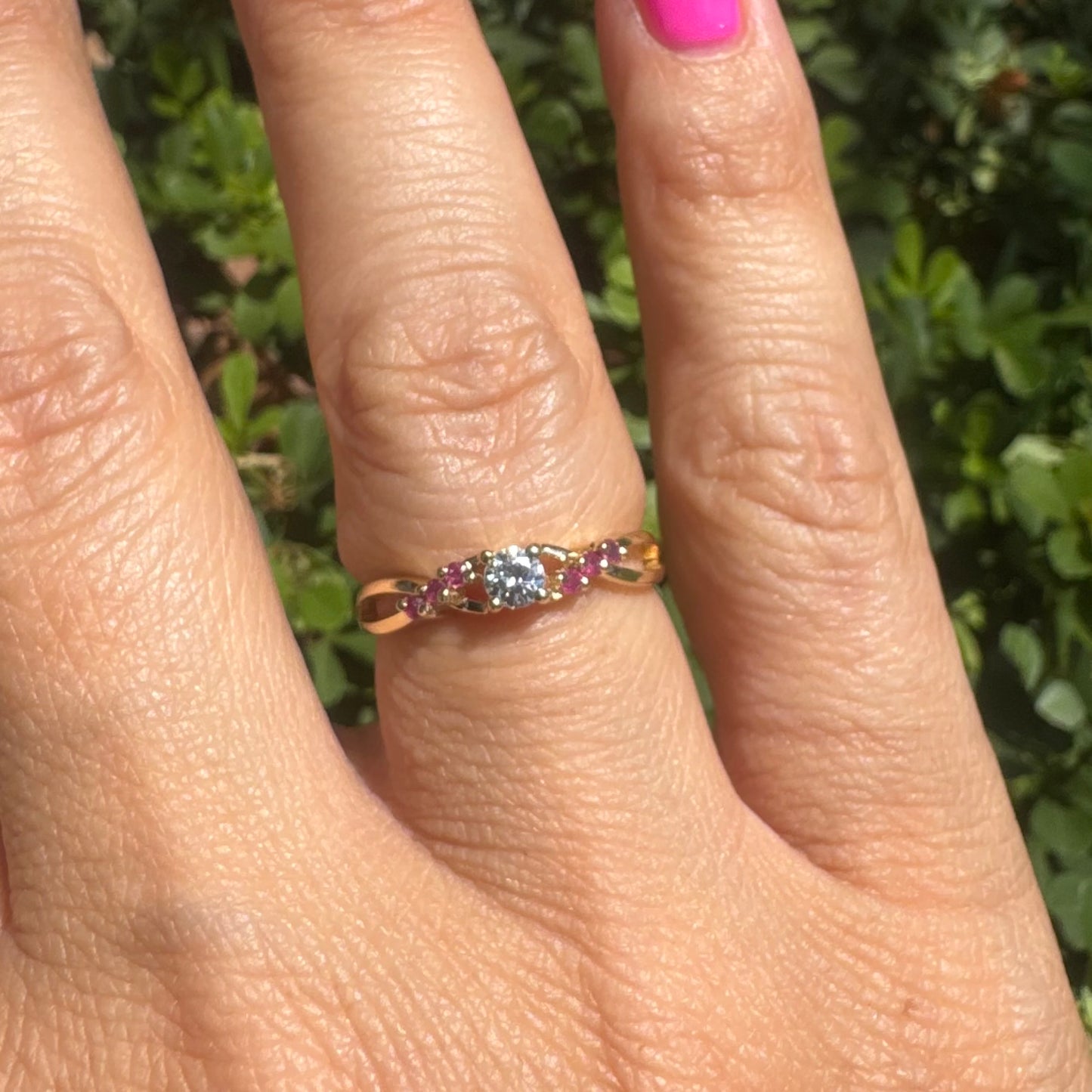 14K gold ring set with a central round Diamond, accented with Rubies along the band.