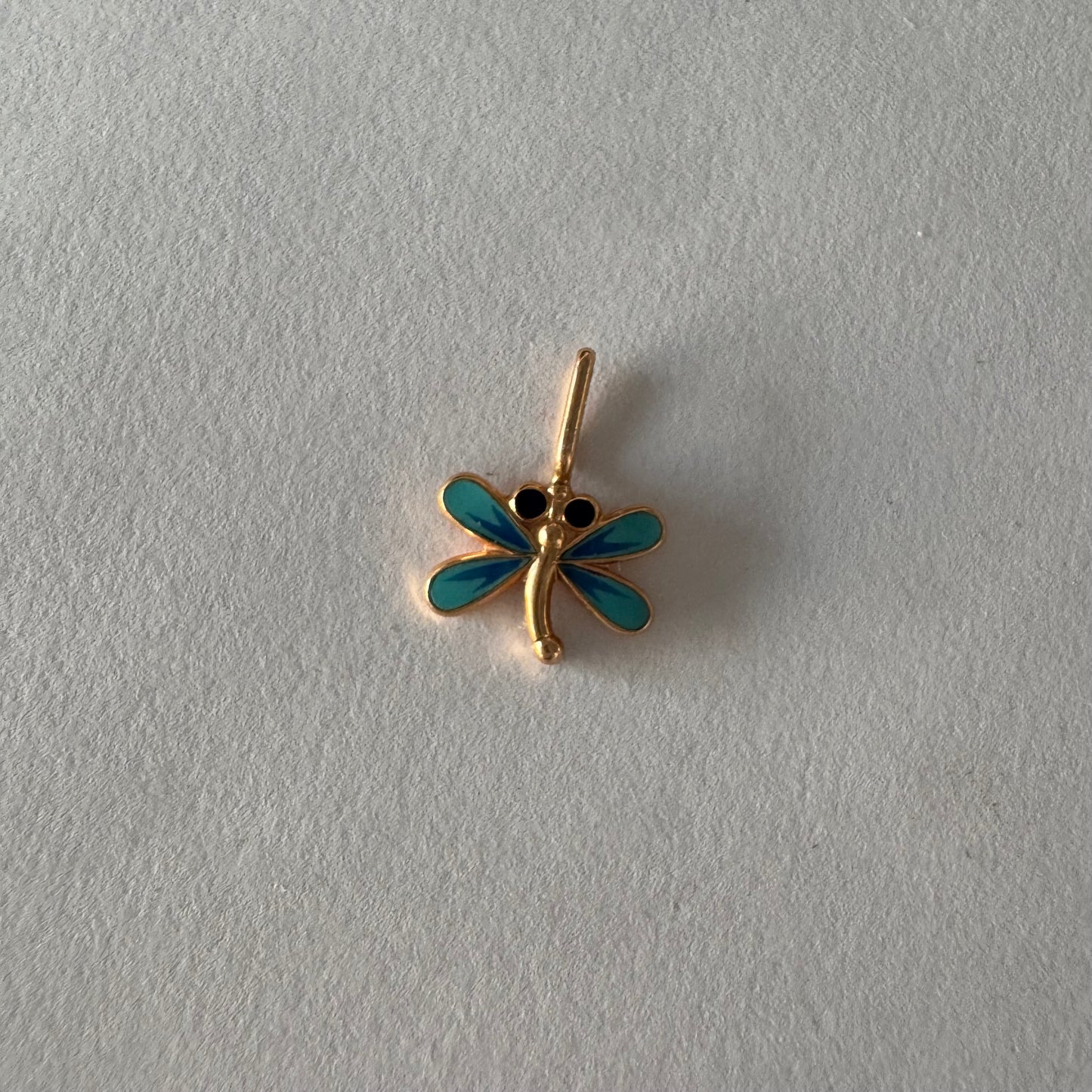 תליון זהב 14 קראט בעיצוב שפירית, עם עבודת אמייל כחולה ופרטים עדינים שמעניקים לו מראה צבעוני ואלגנטי.