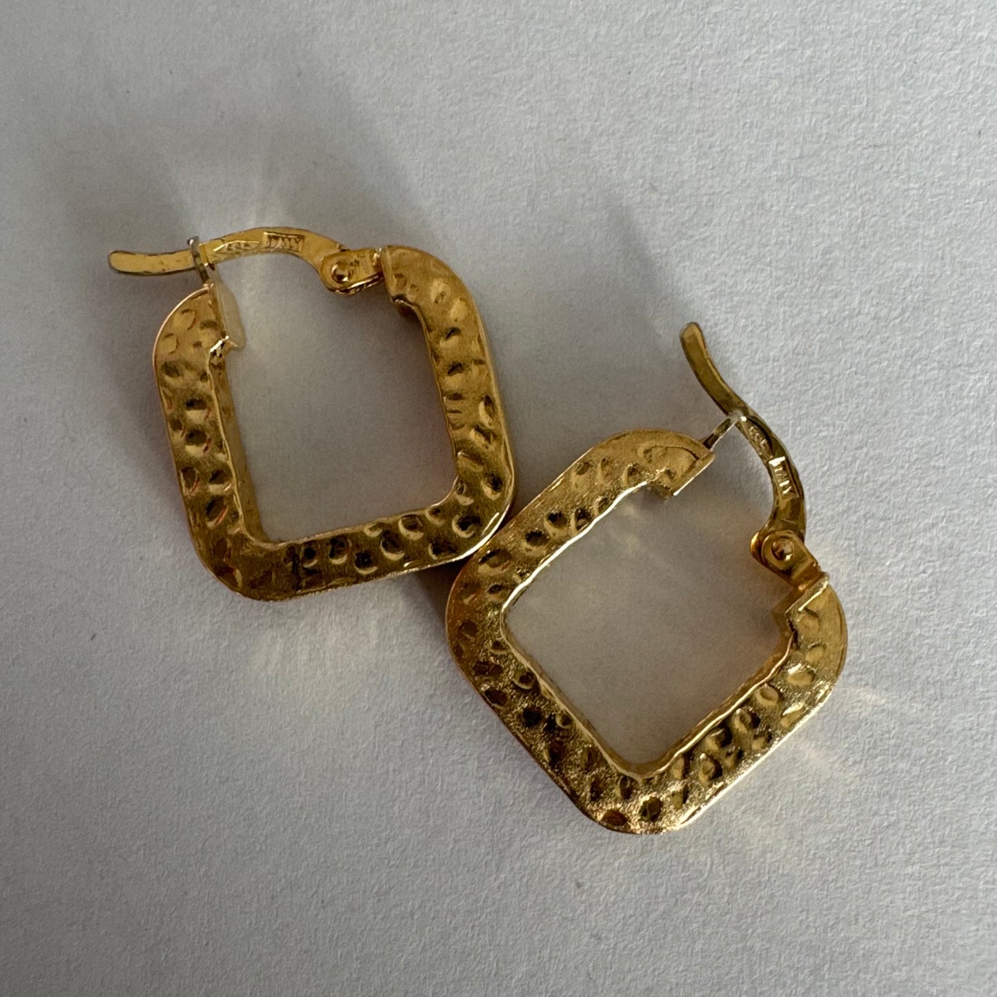 עגילי חישוק מרובעים מזהב 14 קראט בגימור מחוספס ומטאלי. 