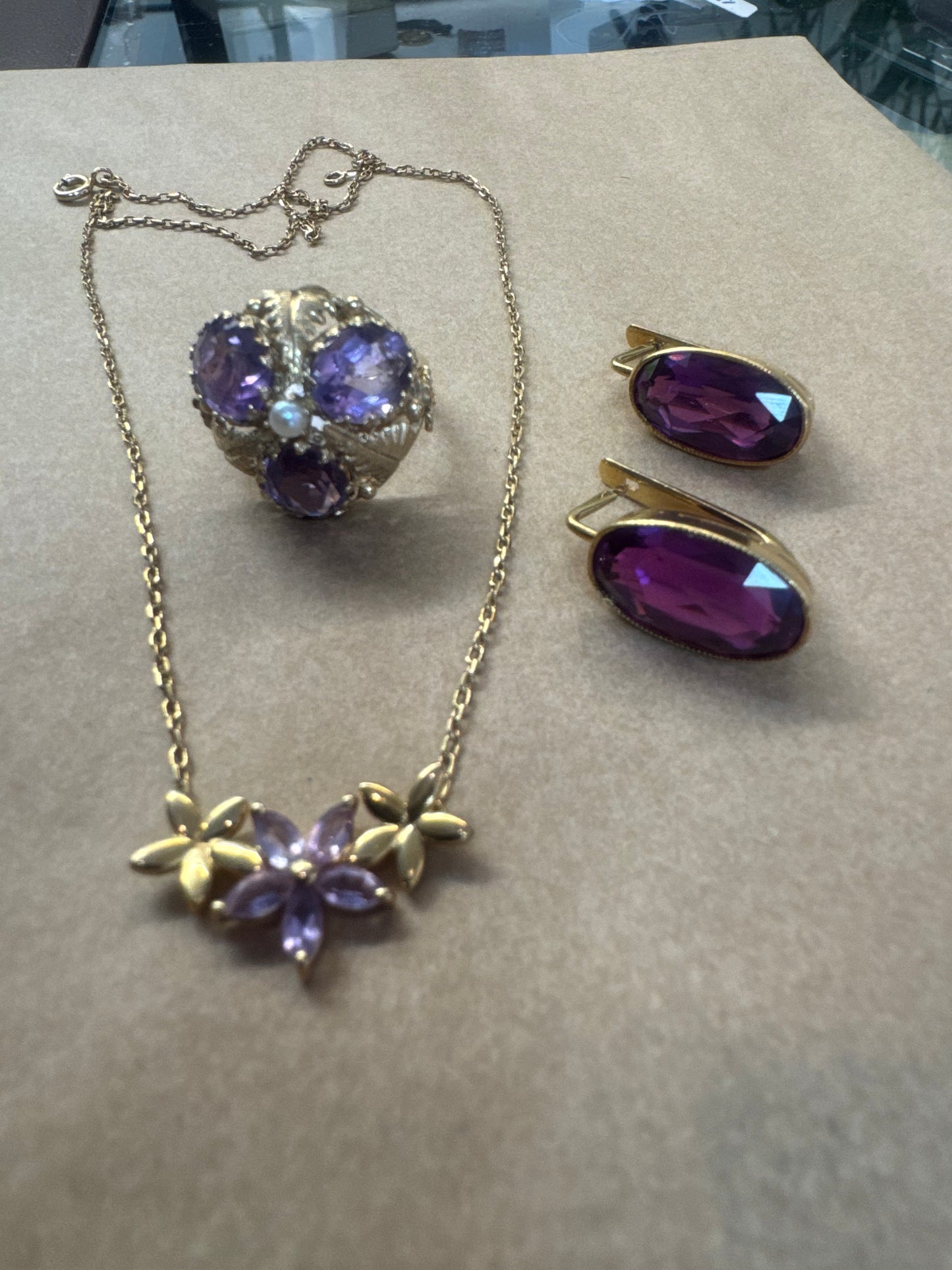 14K gold ring set with four glowing Amethyst stones encircling a delicate central Pearl.