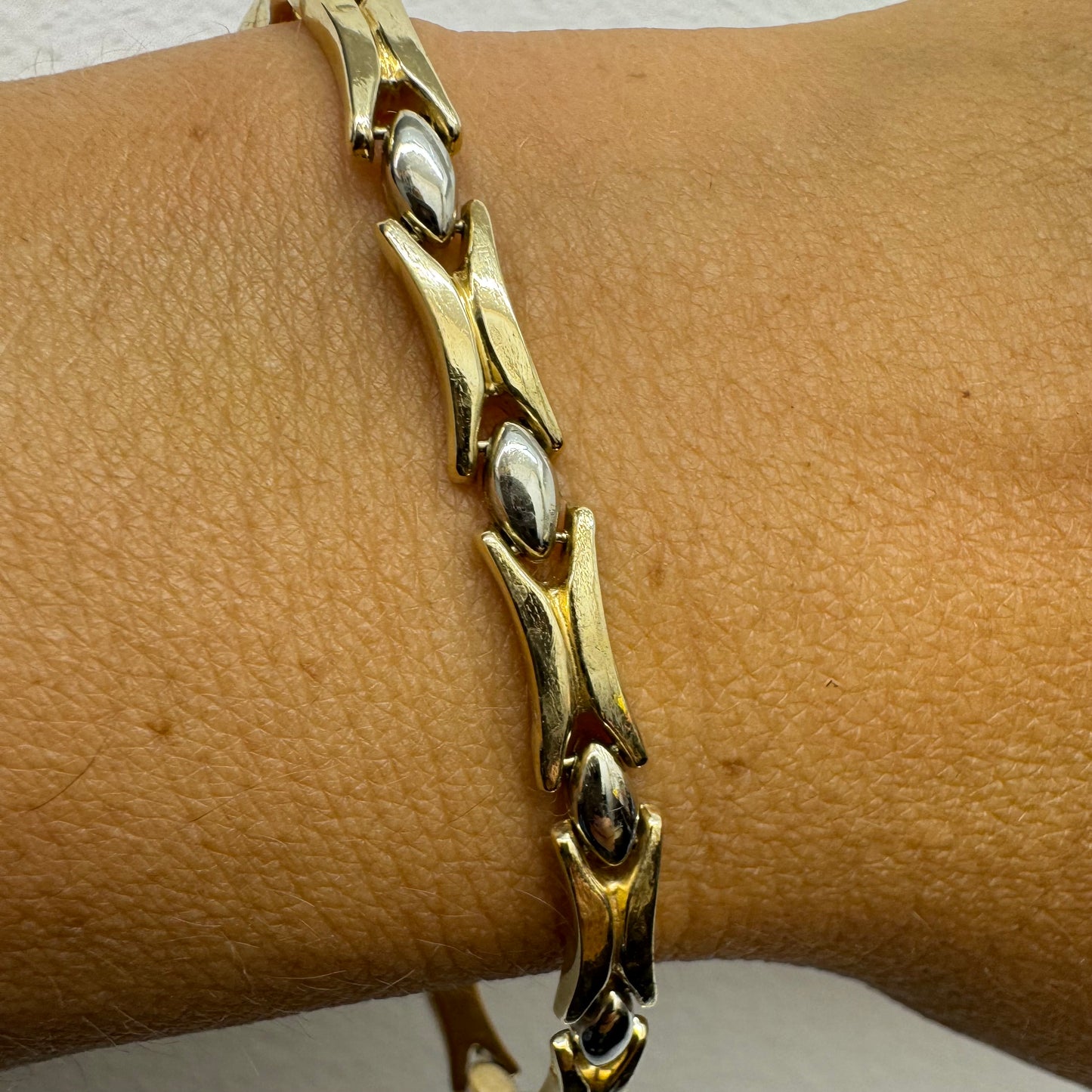 צמיד זהב צהוב וזהב לבן 14 קראט בעיצוב גאומטרי מיוחד, עם חיבורים בצורת X מזהב צהוב ושיבוצים מבריקים בזהב לבן