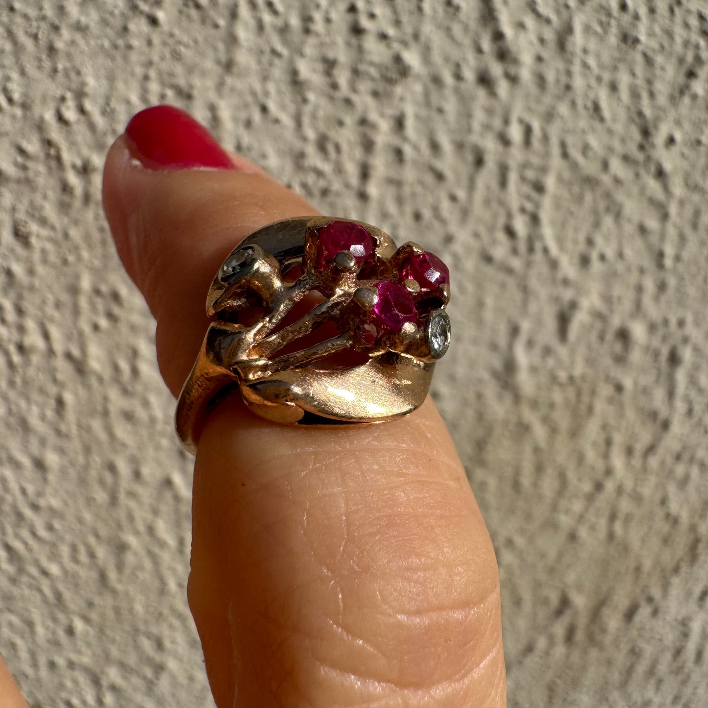 טבעת זהב צהוב 14 קראט, משובצת אבני רובי ושני יהלומים להדגשה, בעיצוב פיסולי ומלא אופי.