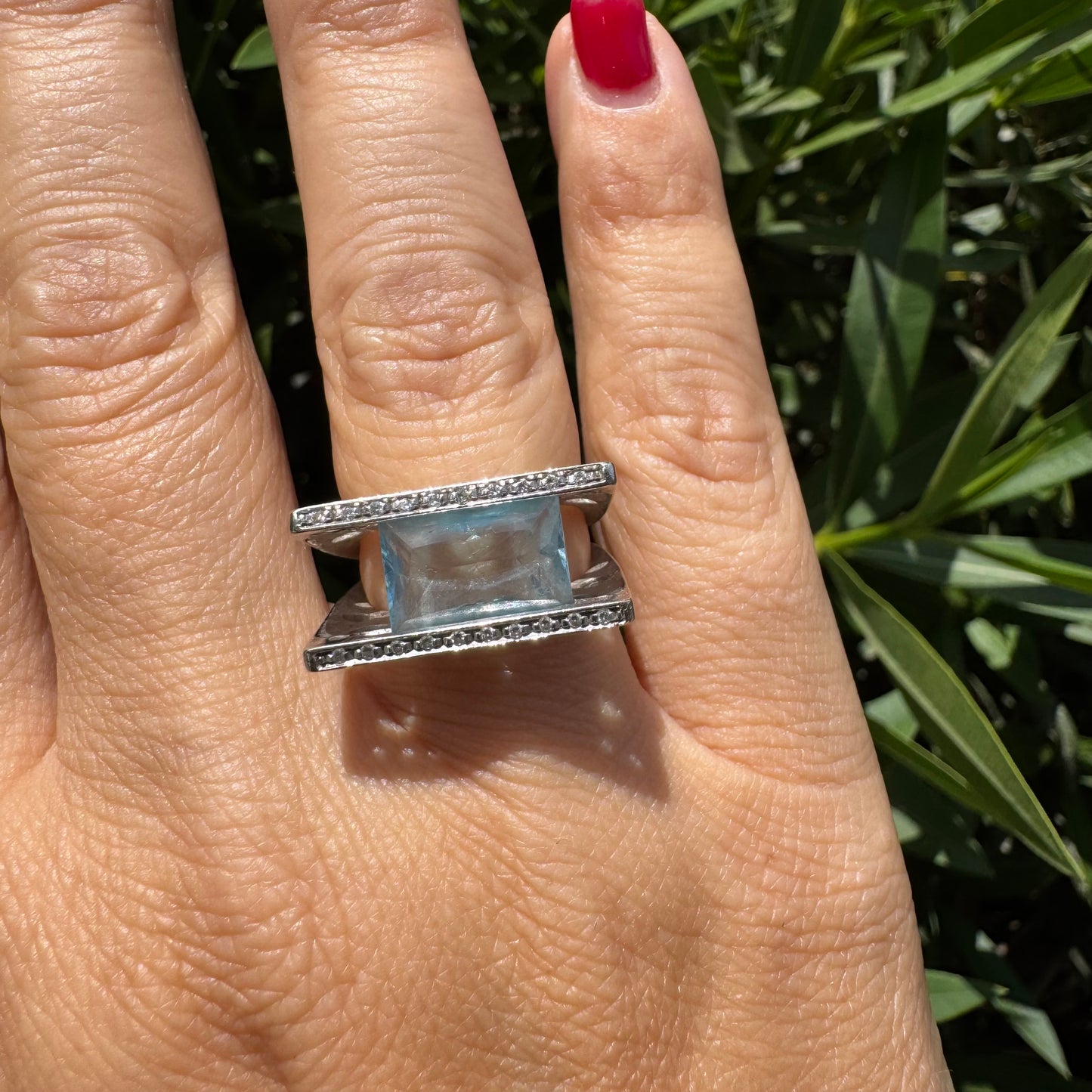 18K gold ring set with a stunning Aquamarine centerpiece held between two sleek gold bars set with delicate Diamonds.